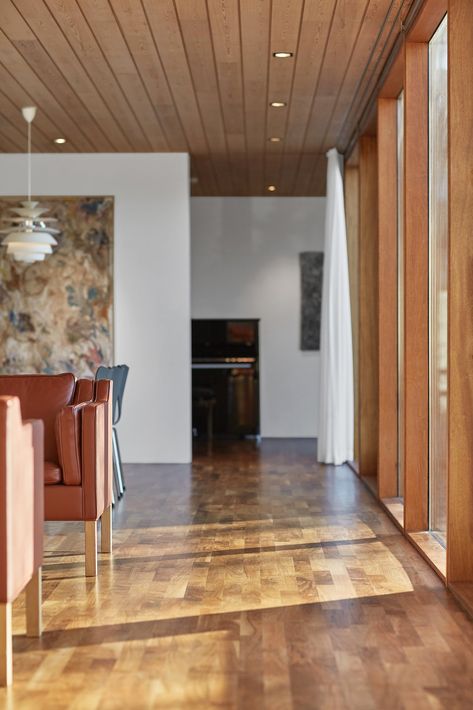 Hallway and Medium Hardwood Floor The original ceiling panels featured pine paneling, which was a familiar choice for Kristinsson. The panels were removed, refinished off-site, and then reinstalled. New ceiling panels of matching pine were installed in the additions. Photo 9 of 13 in A Historic Icelandic Midcentury Gets an Alluring Modern Twist Mid Century Modern Wood Ceiling, Icelandic Interior Design, Wood Paneling Ceiling, Pine Paneling, Midcentury Home, Wood Ceiling, Mid Century Modern Lighting, Mid Century Architecture, Mid Century Modern Interiors