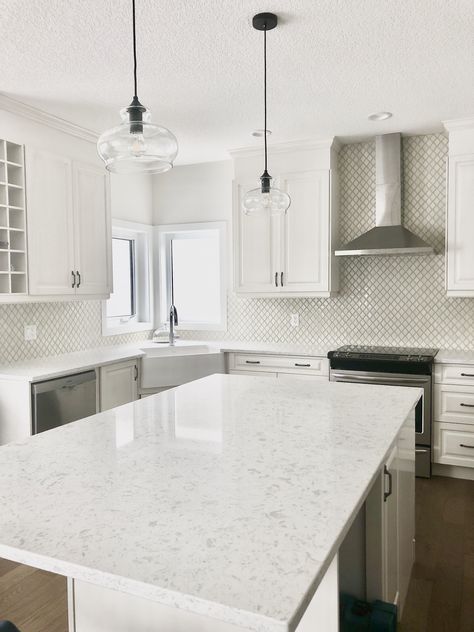 This blend of whites and creams is the perfect combination for anyone who wants a timeless and classic kitchen. #whitekitchen #creamkitchen #whitequartzcountertop #apronsink #whitecabinets #creamcabinets #antiquecabinets #pewterhandles #brightkitchen #farmhousekitchen #highdesignkitchen #arabesquetile #teardroptile #creamtile #raisedpanel #traditionalkitchen #contemporarykitchen #whitewalls #whitecountertops #blackpendants #vintagelights #openconcept #largeisland #marianneelizabethdesign Teardrop Tile, Mosaic Backsplash Bathroom, Cream And White Kitchen, Black Cabinet Handles, Beach Style Kitchen, Custom Backsplash, Transitional Kitchen Design, Coffee Bars In Kitchen, White Shaker Cabinets