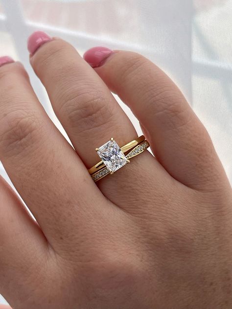 New In! Summer 2023 Promo Sale! One of our bestseller the Alessandra and 2mm half eternity curved moissanite band make a beautiful set together.  💎This beautiful bridal set features 2CT radiant cut 6A CZ diamond stone on a minimalistic 1.8mm 18K yellow gold over Sterling Silver band and a complimentary 2mm curved moissanite band. 💎Made of high quality sterling silver and  heavy plated with yellow gold, rose gold or rhodium it will not rust or turn your finger green. Please be aware that plated jewelry can wear off over time, if this is a concern we would suggest going with the sterling silver ring plated with Rhodium.  Please note: Even though we apply thick layer of gold we strongly recommend to avoid lotions, harsh chemical and water to make sure gold stays on.  💎Will come in a box re Curved Wedding Band With Radiant Engagement Ring, Gold Wedding Band With Silver Engagement Ring, Wedding Band For Cushion Cut Ring, White Gold Engagement Ring With Yellow Gold Wedding Band Stack, Radiant Wedding Ring Set Gold, Silver Engagement Ring With Gold Wedding Band Stack, Wedding Bands For Radiant Cut Rings, Radiant Ring Stack, Silver Engagement Ring Gold Wedding Band