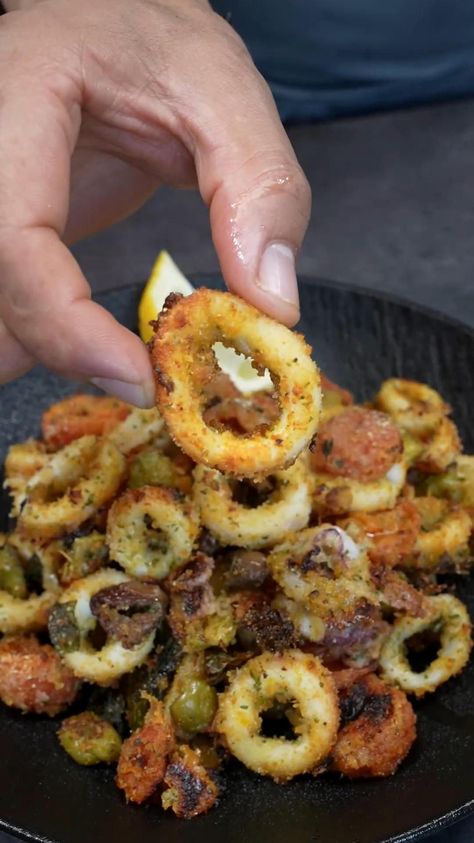 Try this delicious baked calamari dish featuring tender squid rings combined with juicy cherry tomatoes and a mix of green and Taggiasca olives. The dish is topped with savory Parmesan cheese and crunchy breadcrumbs, all enhanced with a hint of oregano, fresh basil, and a zesty lemon touch. Simply arrange the squid rings in a baking dish, layer with the tomato and olive mixture, and finish with a drizzle of olive oil. Bake in a preheated oven at 190°C (375°F) for about 20 minutes until the squid is perfectly crispy. For more culinary inspiration, follow @TheSpatulaOfficial. Credit to @giallovesitally on Instagram. Perfect for a Mediterranean-inspired meal. How To Clean Squid For Calamari, Crispy Squid Recipe, Keto Calamari Recipes, How To Cook Fish In The Oven, Atkins Induction Recipes, Baked Calamari Recipes, Stuffed Calamari Recipes, Fish Oven Baked, Squid Rings Recipe