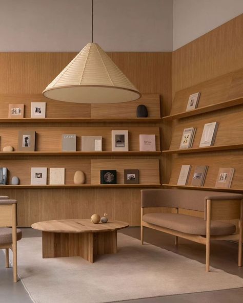 In Copenhagen's historic Ny Østergade, @new_mags has unveiled its flagship store, a quiet oasis designed by @normarchitects , showcasing a curated selection of lifestyle books, collectibles, and magazines. Inspired by the classic library, the design showcases these books as pieces of art, surrounded by carefully selected sculptures and objects. The use of natural materials like oak wood and golden sandstone creates a calm and gentle backdrop, encouraging visitors to delve into the diverse se... Long Study Table, Lifestyle Books, Library Interior, Space Icons, Dragon House, Norm Architects, Store Interior, Office Interior, Nordic Design