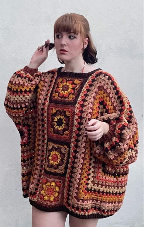 Create your own stylish autumn vibes with this oversized crochet jumper pattern featuring beautiful African flowers! This 70s inspired sweater pattern will have you looking your best this season. It's a great stash buster project and is a perfect project for any level of crocheter. Wear it while camping, at a summer evening BBQ, or for a cosy cover up when the temperature drops. This jumper is sure to become your go-to for a unique and eye-catching sweater. Crochet Sweater 70s, Crochet 70s Pattern, Stash Yarn Crochet Projects, Free 70s Crochet Patterns, African Crochet Patterns, 70s Crochet Sweater, Crochet Hippie Sweater, Crochet Autumn Clothes, Winter Crochet Sweater