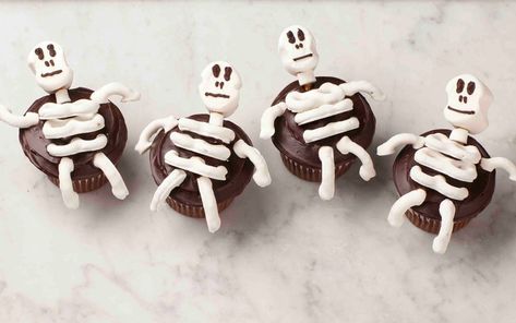 Pretzel Skeleton Cupcakes Are a Cute and Easy Halloween Party Treat Kids Will Go Crazy For | Parade: Entertainment, Recipes, Health, Life, Holidays Easy Halloween Party Treats, Skeleton Cupcakes, Halloween Cupcake Recipes, White Chocolate Banana, The Skeleton Key, Halloween Food Cupcakes, Dark Chocolate Frosting, Halloween Appetizers Easy, Yogurt Covered Pretzels