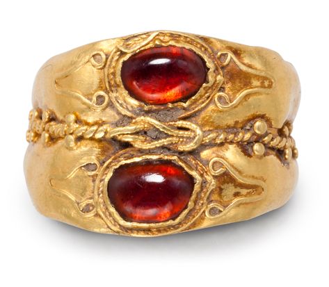 A ROMAN GOLD AND GARNET FINGER RINGCIRCA 2ND-3RD CENTURY A.D.Formed from two hoops, each rounded on the exterior, concave on the interior, expanding to the bezel, with a collar-set cabochon garnet framed by spiral and plain wire filigree, with filigree volutes on the shoulders, the two hoops joined by a spiral filigree wire punctuated by granulation, and centered by a Herakles knot of beaded wire5⁄8 in. (1.5 cm.) wide; ring size 3½PROVENANCEwith Joseph G. Gerena, New York, 1999. Ancient Roman Jewelry, Ancient Jewels, Roman Jewelry, Ancient Jewellery, Rome Antique, Historical Jewellery, Long Pearl Necklaces, Medieval Jewelry, Pearl Jewelry Necklace