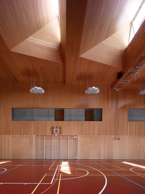 School Complex in Chermignon / Frei Rezakhanlou Architects, wood gym, skylights Gym Architecture, Indoor Basketball Court, Indoor Basketball, Sport Hall, Sports Complex, Hall Design, Salou, School Architecture, Contemporary Architecture