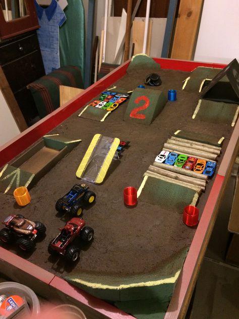 Diy Outdoor Monster Truck Track, How To Organize Monster Trucks, Monster Jam Track Diy, Monster Truck Arena Ideas, Cardboard Monster Truck Track, Diy Monster Jam Arena, Monster Truck Play Area, Diy Monster Truck Track, Monster Jam Truck Storage