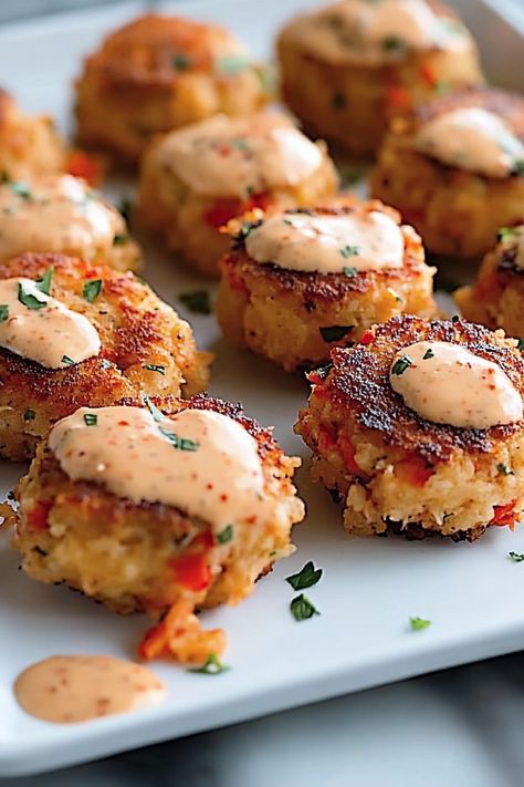 Make these Mini Crawfish Cakes with Remoulade for your next gathering! Each crispy, golden cake is packed with Cajun-inspired flavor and topped with a creamy, zesty red pepper remoulade. Easy to make and a crowd-pleaser, these little bites are perfect for parties, appetizers, or any celebration. Save this recipe and give it a try—you’ll love how quick and delicious it is! Cajun Wedding Food, Crawfish Appetizers, Cajun Appetizers Easy, Cajun Christmas Food, Crawfish Balls, Crawfish Cakes, Crab Beignets Recipe, Crawfish Cake, Cajun Crab Cakes