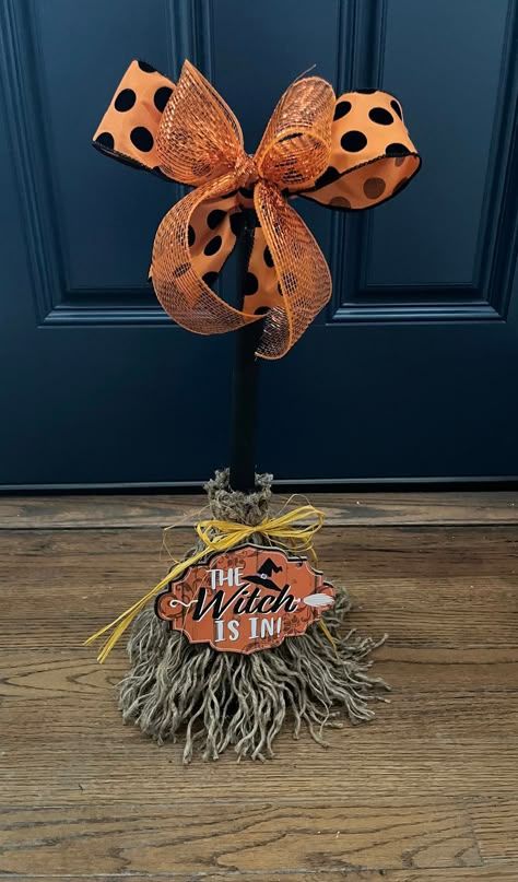 This adorable Witch Broom is all treats and no tricks! A duo of bows sit  atop of a black hand painted broom handle. Jute rope is used as bristles, it is unraveled by hand and attached to the handle. A yellow raffia bow ties up the broom while a sign announcing The Witch Is In sits bottom center of this cute broom! Unique and cute this broom will have you swept away in no time!! Made to order  For decorative purposes only Witch’s Broom, Fall Broom, Witch Brooms, Halloween Witch Brooms, Halloween Brooms, Witch Bells, Witches Broom, Creepy Halloween Decorations, Halloween Traditions