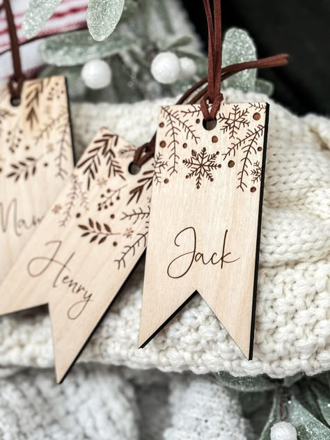 These laser cut and engraved custom wood stocking tags will add a beautiful and personal touch to your Christmas decor that can be used year after year! Each tag comes with a premium suede cord to easily attach the to your stockings. Each tag is made from 1/4 inch birch. Christmas Wood Engraving Ideas, Cricut Wood Engraving Projects, Laser Wood Christmas Ideas, Customized Wood Gifts, Holiday Laser Projects, Laser Engraved Wood Projects, Wood Stocking Tags, Wood Laser Ideas Products, Wood Engraved Ornaments