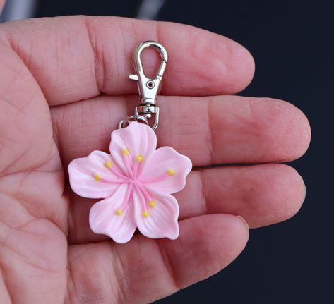 **THIS IS A RESIN CHARM. This sweet little hibiscus zipper charm was just too hard to pass up! The flower is light pink resin, and a perfect accent for a jacket, backpack, laptop bag, luggage, cosmetic bag, purse, planner, wallet, or gym bag.  Makes a great little gift for the hibiscus lover or gardener. Quality and detail is very nice.  Charm is one-sided. Lobster clasp  9mm x 23mm. Clasp base swivels 360 degrees. *INTENDED FOR AGES 12 AND UP. Aesthetic Clay Charms, Girly Keychains, Pink Flower Charm Jewelry For Summer, Flowers Gift, Cute Pink Keychain, Flower Keychain, Backpack Charms, Keychains, Cute Flower-shaped Jewelry With Flower Charm