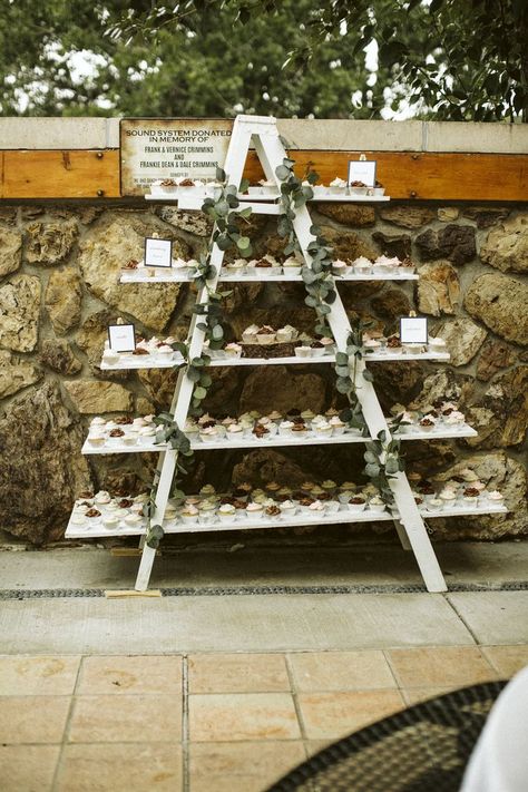 Wedding reception cupcake display with garland. Unique Wedding Cupcake Display, 200 Cupcake Display, Ladder Cupcake Stand, Cupcake Wedding Display Rustic, Boho Cupcake Display, Cake And Cupcake Display Birthday, Large Cupcake Display, Cupcake Ladder Display, Cupcake Table Wedding