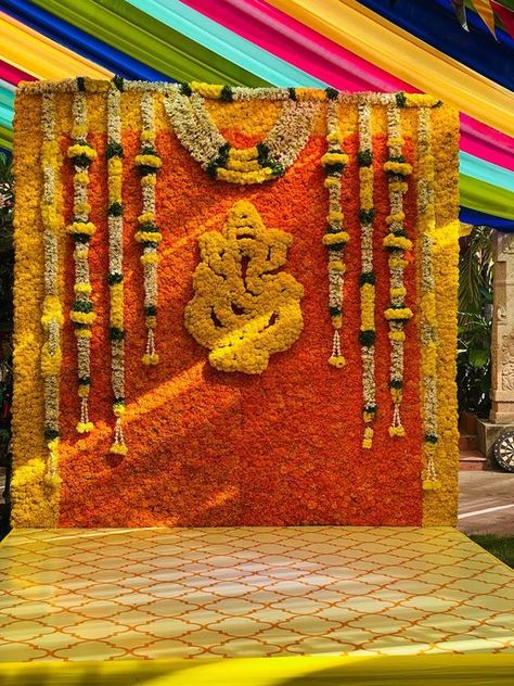 Haldi Decor with Ganesh floral idol in middle looks divine #mehendi #mehendidecoration #mehendidecorideas #mehendidecorationathome #mehendidecoritems #mehendidecorindoor #mehendidecorprops #mehendidecordiy #mehendidecoroutdoor #mehendidecorpinterest #mehendidecorwedmegood #haldi #haldidecor #haldidecoration #haldidecorideas #haldidecorathome #haldidecoritems Flower Pasting Stage Decor, Ganpati Stage Decoration, Pellikuturu Function Decoration, Seemantham Backdrop, Upanayanam Decoration, Traditional Backdrop Decoration, Leaf Decor Wedding, Small Wedding Decor, Simple Stage Decorations