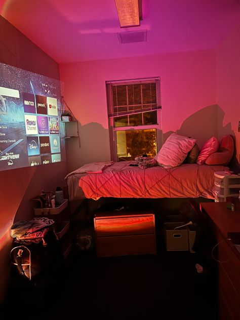 dorm room decor, a projector with LED lights! comfy bed and good space Projector Dorm Room, Led Light Dorm Room, Projector In Dorm Room, Dorm Room Projector, Dorm Room At Night, Cozy College Dorm Aesthetic, College Dorm Led Lights, Led Dorm Room Ideas, Dorm Room Ideas Led Lights