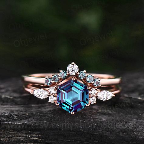 "This is a Alexandrite engagement ring in solid gold,about 6x6mm Hexagon. The accent stones are round 1.5mm and marqueise 2x4mm moissanites. The matching bands stones are round 1.5mm Alexandrites and moissanite. Only the engagement ring: https://www.etsy.com/listing/1024656125/hexagon-alexandrite-engagement-ring-art It can be made in any ring size. However please contact me to custom make it to a special big or small size. It can be made in white gold,rose gold or yellow gold with 14k or 18k. Ho Alexandrite Engagement Ring Hexagon, Alexandrite Ring Set, Alexandrite Halo Engagement Ring, Rose Gold Alexandrite Wedding Ring, Synthetic Alexandrite Engagement Ring, Hexagon Engagement Ring, Moissanite Wedding Ring Set, Alexandrite Stone, Shiny Rings