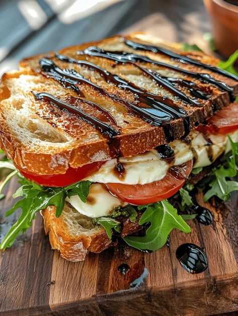 Indulge your senses with the Italian Delight Toasted Sandwich! This mouthwatering creation brings together the goodness of ciabatta bread, creamy mozzarella, savory prosciutto, and fresh arugula, all enhanced with fragrant basil pesto and a drizzle of balsamic reduction. Whether you’re looking for a simple weeknight meal or something special for a brunch gathering, this sandwich is sure to i... Healthy Prosciutto Recipes, Sandwiches With Mozzarella, Sundried Tomato Sandwich Recipes, Baked Sandwich Recipes, Panzanella Sandwich, Brunch Sandwich Ideas, Hot Sandwiches For Dinner, Cafe Sandwich Ideas, Fancy Sandwiches Ideas