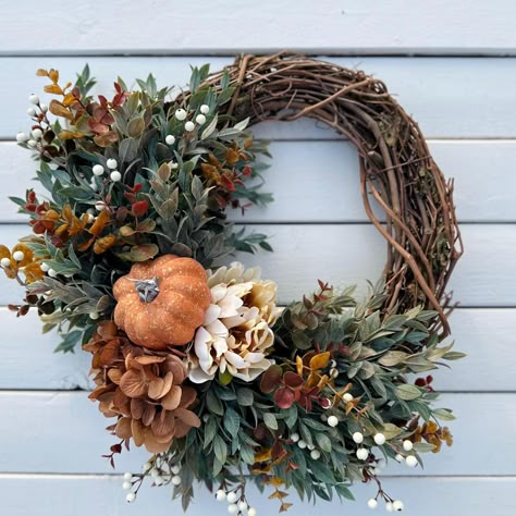 This beautiful fall pumpkin wreath will be the perfect addition to your front door this holiday season to greet your guests.  Arranged on a natural grapevine base this wreath has a orange pumpkin with a brown hydrangea and cream peony, surrounded with berries, ruscus greenery and eucalyptus with different shades of fall colors. All materials are high quality faux.  This wreath is made on a 14" grapevine base and measures approximately 18" from leaf tip and across in the widest area. Wreaths make perfect gifts for any occasion - for teachers, gift for mom, anniversaries, showers, birthdays, housewarming and even real estate.  Please be sure to keep wreath inside or covered outside. Keep out of direct sunlight and away from moisture.  Be sure to follow my shop for sales and new items. You ca Ruscus Greenery, Pumpkin Fall Wreath, Unique Place Cards, Easy Thanksgiving Table Decor, Thanksgiving Table Decor Ideas, Fall Feast, Halloween Door Decor, Easy Fall Wreaths, Fall Hydrangea