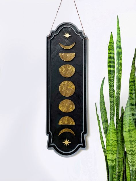 If you are looking for a new gallery wall piece that will make a statement, you found it with our Phases of the Moon Wall Hanging. Its size of 18.5" tall will make a stunning addition to your curated gallery wall. We offer this in two colorways: Black with Gold accents and Walnut with Rose Gold accents.Make sure you take a look at the detail image which shows the intricate engraving. Since each piece is unique, the pictures will vary from what’s shown online depending on engraving depths.PRODUCT Black Wall Hanging, Dark Bohemian, Moon Phases Art, Magical Accessories, Occult Symbols, Boho Eclectic, Celestial Art, Crystal Magic, Celestial Jewelry