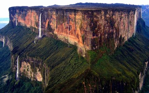 The Guiana Highlands is a very unusual mountain range covering parts of Venezuela, Brazil, Guyana, Suriname and French Guiana. The highlands are made of ancient sedimentary rock that is over two billion years old and are some of the oldest sedimentary rocks on the planet.  The mountain is known as a Tepui, which describes a flat-topped mountain with vertical sides. Many waterfalls spill off Roraima, and the other Tepuis Monte Roraima, Mount Roraima, Socotra, The Lost World, Breathtaking Places, Sanya, Bagan, Oh The Places Youll Go, Places Around The World