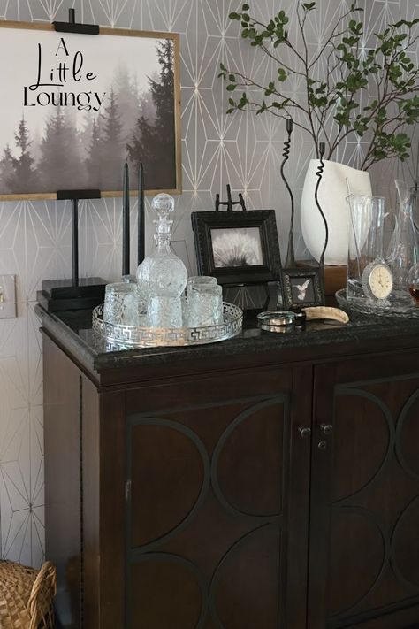 Recreate my beautiful wine bar.Layers are the key to a well dressed table, tray or shelf. Martini pitcher, Tray, Magnifying Glass, Faux stems, artwork, rocks glasses, Forged Iron Candlesticks from Amazon. Bar Tray Styling, Bar Bathroom Ideas, Martini Pitcher, Faux Stems, Bar Tray, Iron Candlesticks, Pottery Barn Inspired, Nancy Meyers, Bar Storage