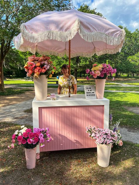 Our beloved flower cart has seen so many beautiful upgrades over the years! 🌸 Currently, it features an adorable pink and white umbrella with the sweetest fringe. Now, it's time for a change! What color umbrella should we choose next to keep our wedding floral arrangements fresh and enchanting? 🌷💐 Vote for your favorite and see the transformation with Doris Ione, your go-to wedding florist for dreamy floral designs! Flower Stand Ideas, Boutique Store Front Ideas, Cart With Umbrella, Flower Bar Ideas, Vendor Stand, Wedding Floral Arrangements, Jewelry Booth, Sweet Carts, Girly Decor