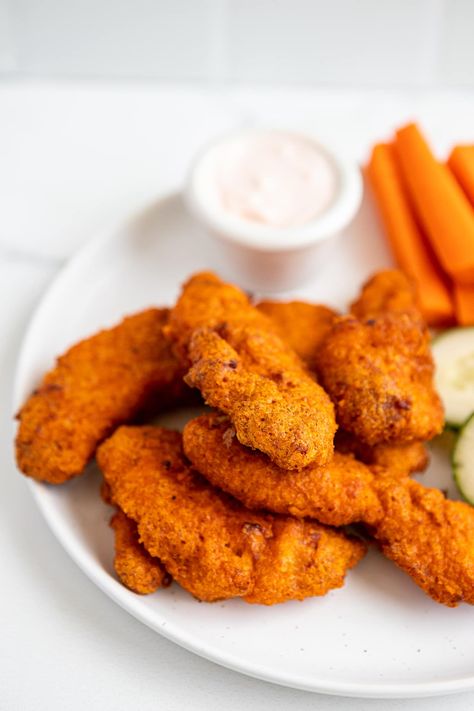 buffalo chicken strips stacked on top of each other with carrots and ranch in the background Carrots And Ranch, Homemade Buffalo Chicken, Buffalo Chicken Strips, Buffalo Chicken Tenders, Chicken Tenders Recipe, Spicy Buffalo Chicken, Chicken Tender Recipes, Chicken Strips, Buffalo Chicken