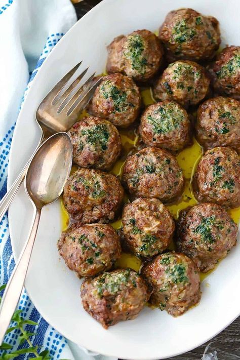 These super flavorful Greek Meatballs (keftedes) are baked instead of fried and drizzled with herbs and melted butter before going in the oven! #GreekMeatballs #GreekFood #Keftedes Greek Dinners, Greek Meatballs, Greek Cooking, Greek Dishes, Herb Butter, Seitan, Mediterranean Diet Recipes, Greek Recipes, Mediterranean Recipes