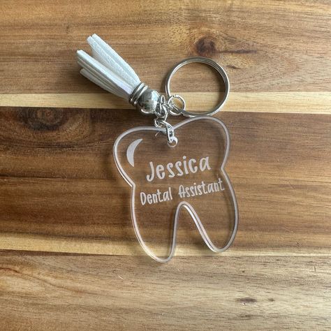 This keychain is a must-have for any dental professional, student, or enthusiast. Carrying this keychain is a subtle yet powerful way to express your commitment to dental care and hygiene. Whether you're a dentist, hygienist, or simply someone who loves their smile, this keychain is the perfect way to accessorize and showcase your dental pride. 🦷 Product Features: - Cute tooth design with "Dental Assistant or other title" engraving. - Made of durable acrylic - Perfect size for keys or to attach Tooth Keychain, Dentist Hygienist, Dental Assistant Gifts, Cute Tooth, Tooth Design, Dental Student, Assistant Gifts, Dental Assistant, Student Gift