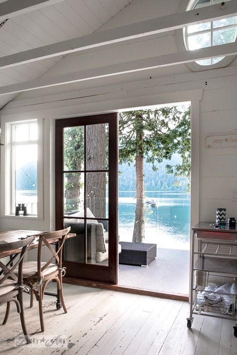 An oval transom window in a peaked planked vaulted ceiling in a dreamy white shiplapped lake cottage at Cultus Lake, BC Cottage Ceiling Lights, Planked Vaulted Ceiling, Tiny Lake Cottage, Lake Cottage Aesthetic, Modern Lake Cottage, Lake Side Cottage, Lake Cottage Interiors, Lakehouse Aesthetic, Small Lake Cottage Interiors