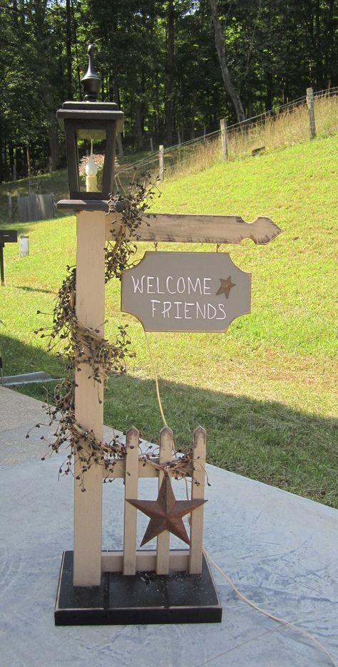 Primitive Outdoor Decor, Exterior Holiday Decor, Outdoor Lamp Post, Wooden Post Ideas, Diy Lamp Post Outdoor, Diy Lamp Post, Welcome Sign Made From Pallet Wood, Fence Picket Welcome Sign Diy, Rustic Solar Lamp Post