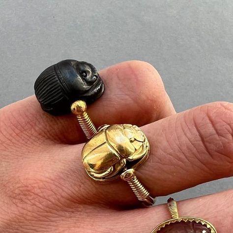 Kunsthandel Inez Stodel on Instagram: "Egyptian Revival Scarab rings An 18 carat gold scarab ring swivel set with a rotating stylised Ancient Egyptian scarab between tapering shoulders wrapped in gold wire, with a rounded shank, the reverse of the scarab is blank, opening to reveal a hidden locket compartment, French assay marks for gold and maker's mark, circa 1870, France. weight: 15.46 grams dimensions scarab: 16 x 11 x 8.3 mm ring size: 18.25 mm / 8 US An 18 carat gold ring with a rotatin Scarab Ring Gold, Scarab Ring, Scarab Beetle Jewelry, Scarab Beetle Amethyst Jewelry, Egyptian Scarab Necklace, Scarab Bracelet Vintage, Egyptian Scarab, Egyptian Revival, Maker's Mark