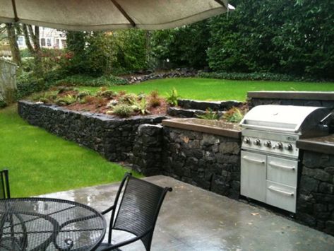 I used basalt for the dry stone (no mortar) retaining wall and steps. The kitchen area is situated on top of a single car garage. The counter tops and mantle are concrete with a sand finish. An... Stone Outdoor Kitchen, Fine Homebuilding, Mediterranean Landscape, Outdoor Kitchen Countertops, Sloped Backyard, Grill Area, Backyard Kitchen, Dry Stone, Granite Countertops Kitchen