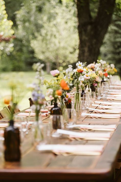 Colorful Spring Wedding Reception Decor | Whimsical, colorful outdoor wedding reception set up. The long table is beautifully decorated with vibrant flowers and set with peach-colored napkins. Discover whimsical wedding centerpiece, whimsical wedding color palette, mountain wedding colors and wedding reception aesthetic. Book Nina for your Colorado wedding or adventure elopement at larsenphoto.co! Long Table Outdoor Wedding, Simplistic Outdoor Wedding, Single Table Wedding Reception, River Wedding Reception, Simple Wildflower Table Setting, Minimal Long Table Wedding Decor, Backyard Wedding Table Settings, Outdoor Wedding Reception Table Decor, Wildflower Farm Wedding