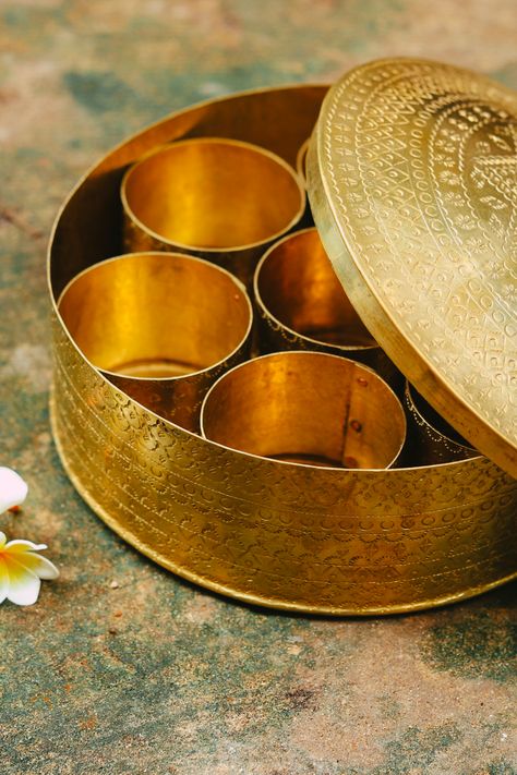 Etched into the shining metal, Mandalas and motifs, They are, but, Craftsmanship's fine example. Golden brass, That reflects in light... Gift a set to someone, Or serve food in them, Add nutrition to food... With a bit of shiny style! #spicebox #masala #india #brass #design #product #handmade #gaatha #kitchen #utensils Indian Kitchen Utensils, Masala Dabba, Bullock Cart, Indian Masala, Herb Storage, Indian Kitchen, Spice Box, Spice Jar, Indian Crafts