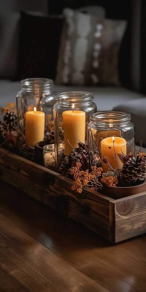 A beautiful rustic centerpiece featuring a variety of amber jar scented candles, pinecones, and dried flowers, arranged on a wooden tray.

Picture 3: Dining Candle Centerpiece, Coffee Tray Decor Ideas, Dining Room Candle Centerpiece, Amber Glass Christmas Decor, Popurri Decor, Aesthetic Dining Table Decor, Christmas Living Room Decor Small Spaces, Candle Glass Jar Ideas, Coffee Centerpieces