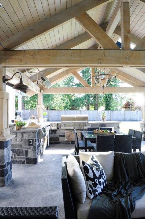 Covered patio features a rustic wood truss ceiling over an L shaped gray stone outdoor kitchen fitted with a stainless steel bbq. L Shaped Outdoor Kitchen, Covered Patio Ideas, Pergola Diy, Wood Truss, Covered Back Patio, Outdoor Kitchen Countertops, Porch Ceiling, Patio Pergola, Backyard Kitchen