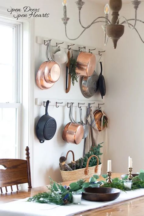 mixed metal pots and pans hanging on the wall racks winter decor ideas for the home Wall Pot Racks Ideas, Wall Pot And Pan Rack, Kitchen Pan Hanging Rack, Where To Hang Pots And Pans, Kitchen With Pans Hanging, Hanging Rack For Pots And Pans, Kitchen Wall Pot Rack, Hang Pots On Wall, Wall Mounted Pan Rack