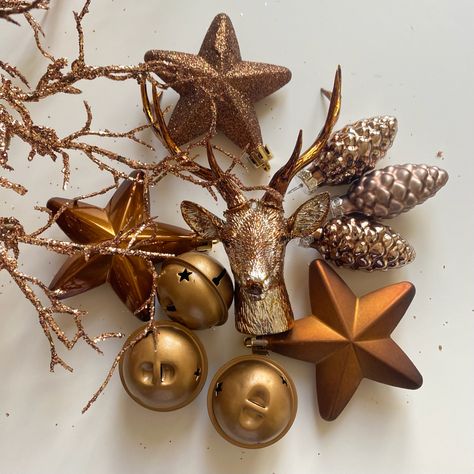 Bronze and gold stars, bells and pine cones and a bronze stags head decoration Copper And Gold Christmas Decor, Bronze And Gold Christmas Decor, Brown And Gold Christmas Decor, Bronze Christmas Decor, Gold Christmas Aesthetic, Monochromatic Party, Bronze Christmas Tree, Brown Christmas Decorations, Copper Christmas Decor