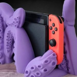 Materials: PLA, Plastic, Biodegradable Plastic

Nintendo Switch Tentacle Dock Cradle, Table Stand, Gamer Gifts 3D Printed Desk Accessories Biodegradable Plastic, Gamer Gifts, Desk Accessories, Roleplaying Game, Nintendo Switch, Biodegradable Products, Desk, Gifts