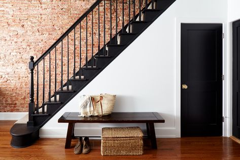 Stairwell with exposed brick wall. Black painted doors, treads, risers, and railing. Exposed Brick Stairwell, Staircase Wallpaper Ideas, Stairs Wall Decor Ideas, Stairs Wall Decor, Staircase Wall Design, Coastal Blue Paint, Classic Staircase, Stairwell Ideas, Transitional Staircase