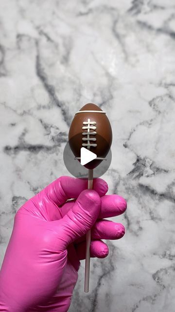 Sweet Whimsy Shop | Cake Pops | Bakery & Tutorials on Instagram: "Wondering how I make football cake pops? I roll “cake dough” into a ball, then sculpt into an oval-ish shape, and then I pinch both ends to create the football shape. I add a stick, then dip the shaped cake ball into melted milk/brown compound chocolate. For the stripes, I pipe 2 lines of white compound chocolate at each end, a perpendicular stripe in the middle, and then I add 5 short lines on top of that. Is that what you do? 🍰🏈🎉
.
.
.
#cakepops #savannahbakery #richmondhillbakery #savannahcakepops #homebaker #bakingtips #cakepoptips #cottagefoodbaker #footballcakepops #footballparty" Superbowl Cake Pops, Football Cake Pops, Football Themed Food, Football Desserts, Brownie Cake Pops, Superbowl Cake, Compound Chocolate, Football Treats, Sports Themed Cakes