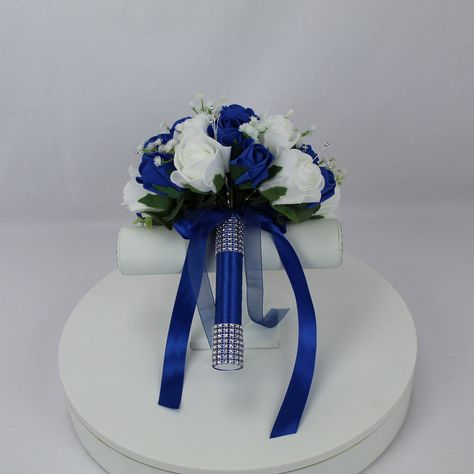 Realistic Artificial Blue & White wedding bouquet singles All bouquets have been made with quality flowers & our custom made diamante clusters & spays. The bouquet handles have been wrapped with satin/diamante ribbon and come with colour coordinated satin bows. These bouquets are available in 6 standard sizes & all buttonholes come with pin attached. We can also provide custom packages on request.  Approximate sizes; Teardrop - 14 x 10 inches Extra Large bouquet - 11 inches (27.5cm) Large bridal White Rose Bouquet With Blue, Royal Blue And White Bouquet, Blue Black And White Bouquet, White Rose And Blue Flower Bouquet, Royal Blue And Silver Flower Bouquet, Bouquet Royal Blue, Blue And White Bouquet, Ivory Bouquet Wedding, Graduation Flowers