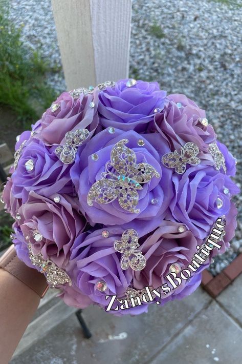 An elegant and beautiful bouquet! Customize bouquets are also available if needed. Different colors and brooches. 10inches in diameter You are welcome to message me and I will reply quick :) Hablo español 😊 Butterfly And Flower Quinceanera Theme, Purple Quinceanera Bouquet, Purple Quince Decor, Lilac Quinceanera Decorations, Quinceanera Flower Bouquet, Quince Purple, Quinceanera Purple, Quince Bouquet, Quinceanera Flowers