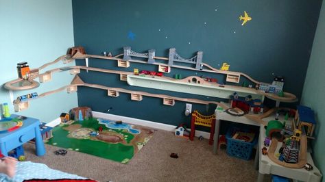 Train track wall,  used balsa wood for the train tracks to run along.  Then i used $1 craft crates from Michaels to hold it up.  Attached an a spray painted record to a standard shelf bracket to allow the track room to turn around at the ends.  I also incorporated a shelf we already had in the room... Diy Train Tracks On Wall, Train Play Ideas, Wooden Train Track Storage, Wall Train Track, Train Around Room, Wall Track For Cars, Thomas The Train Room Ideas, Car Track On Wall, Train Room For Boys