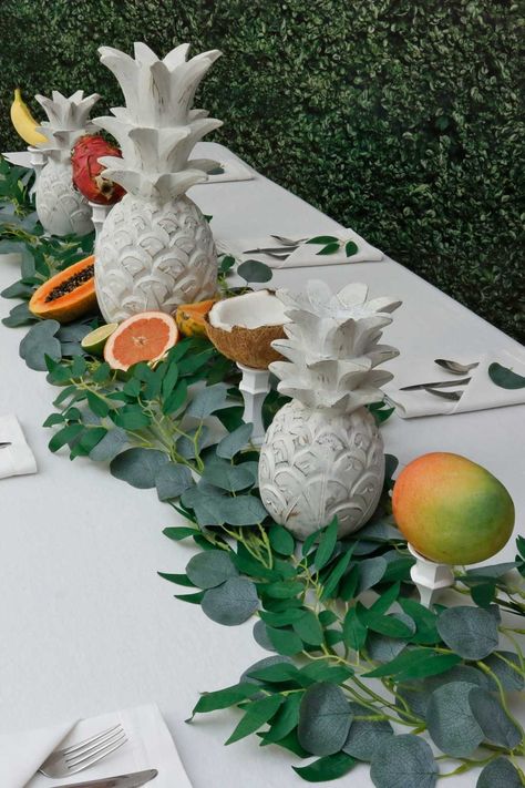 Capture the vibrant essence of the tropics with an elegant tablescape of whitewashed pineapple sculptures, lush greenery & a colorful array of fresh fruits. Coastal Birthday, Coral Party, Christmas Candle Centerpiece, Fruit Centerpieces, Painted Candlesticks, White Candle Sticks, Luau Theme Party, Luau Theme, Willow Leaf