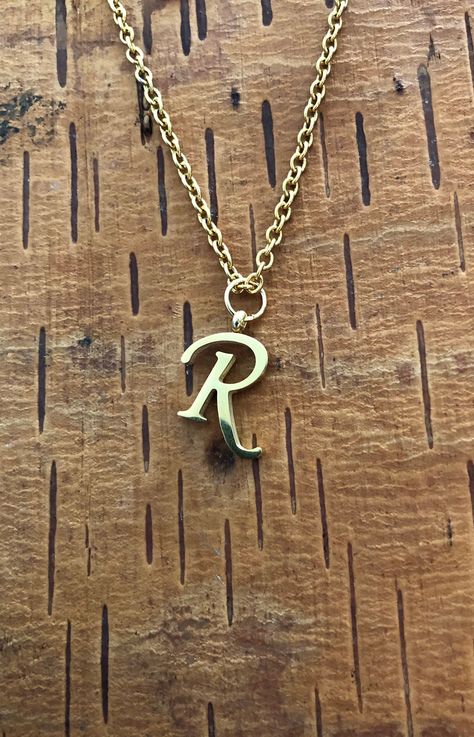 "Letter R necklace, set on a stainless steel ,golden color chain. Chain length 19'  With addition cost there is an option to add a white freshwater pearl, as a charm, next to the letter. 6 mm, white round pearl Kindly choose your option. Beautiful spiritual gift. Please make sure you to pay attention to the size of the pendant. I have added pictures next to 25 cent coin, and measurement tape.  Need a different length just write it to me in the \"message to the seller\" box of the order form. **L Gold R Necklace, R Pendant Letter Gold, R Necklace Letter, R Letter Necklace, R Wallpaper Letter Aesthetic, Letter R Necklace, R Initial Necklace, R Name, R Necklace