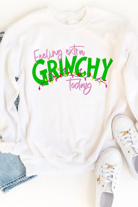 A white pullover sweatshirt for women with a Christmas design on the front that says: Feeling extra Grinchy today. The grinchy font is in green. Christmas Sweatshirt Ideas, Grinch Christmas Sweater, Christmas Sweater Women, Christmas Outfit Casual, Funny Grinch, Grinch Shirts, Cute Christmas Outfits, Christmas Party Shirts, Diy Sweatshirt