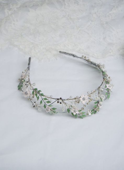 "This romantic dainty flower headpiece is created for the modern bride.  looks lovely worn at weddings, Events, anniversaries and many other special occasions. Features: - Green Leaves and white clay flowers are hand wired  - Adorned with assorted beads - Lightweight and flexible  Approximate Measurements  14\" Wire band length   1.5\" Tallest point when worn ------------------------------------------------ *Disclaimer: Due to the handmade nature of this product each headpiece is truly unique and special in its own way and may have slight variations Please keep in mind before purchasing this product is \"MADE TO ORDER\" and has a production time of 1-2 weeks + shipping time to your area Shipping:  Please make sure you read FAQS and shop policies on my page before purchasing  all postage ti Light Green Tiara, Light Green Quince Crown, Wedding Headpiece Tiara, Sage Green Tiara, Beaded Tiara, Bride Looks, Bridal Crown Tiara, Handmade Tiaras, Wedding Tiaras