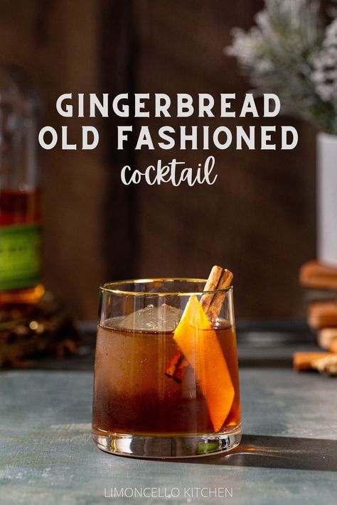 Gingerbread Old Fashioned cocktail in an old fashioned style glass. The drink is brown and has a large sphere of ice in the glass along with an orange peel and a cinnamon stick garnish. In the background to the left is a bottle of Bulleit rye whiskey, and to the right is a vase with snowy looking evergreens with a stack of wooden coasters under the vase. Text overlay above the cocktail reads “Gingerbread Old Fashioned cocktail”. Gingerbread Bourbon Cocktail, Cinnamon Holiday Cocktails, Ginger Old Fashioned Cocktail, Gingerbread Old Fashioned, Ginger Bread Cocktail, Cinnamon Syrup Cocktail, Gingerbread Whiskey Cocktail, Gingerbread Cocktail Holiday Drinks, Gingerbread Old Fashioned Cocktail