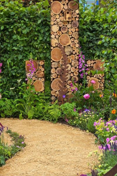 Log and wood bug hotel in Stop and Smell the Flowers by Julie Haylock. Logs In Garden, Bug Hotel Ideas, Smallholding Ideas, Logs Ideas, Bin Store Garden, Coloured Furniture, Bug Garden, Gardeners World, Stop And Smell The Flowers