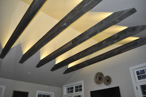 Beams are wrapped in old barn siding that give them a rustic look. Recessed lights also help illuminate the room and highlight the cathedral ceiling. Victorian Attic, Skylight Bedroom, Modern Attic, Low Ceiling Attic, Small Attics, Attic Decor, Attic Wardrobe, Attic Lighting, Cave Basement